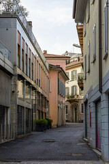 Narrow street with historic buildings in the center of Monza, Italy
