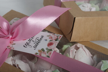 Marshmallows in boxes with a transparent lid. The box is tied with a ribbon. The inscriptions are "Made with love". Homemade marshmallows. Tulips made of marshmallows.  Close-up.