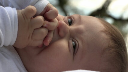 Contemplative baby child thinking thoughtful infant laid in ground looking to sky