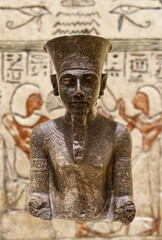 Klasyczna, tajemnicza egipska rzeźba, posąg na tle hieroglifów. Dekoracja.