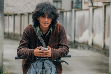 young man with bicycle using mobile phone on the street