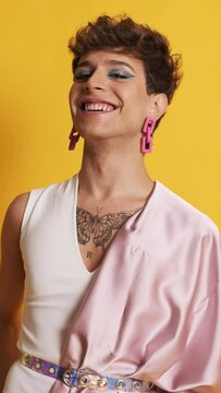 Transgender person with pink clothes and make up smiling at the camera