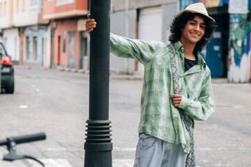 funny young man leaning on street lamp