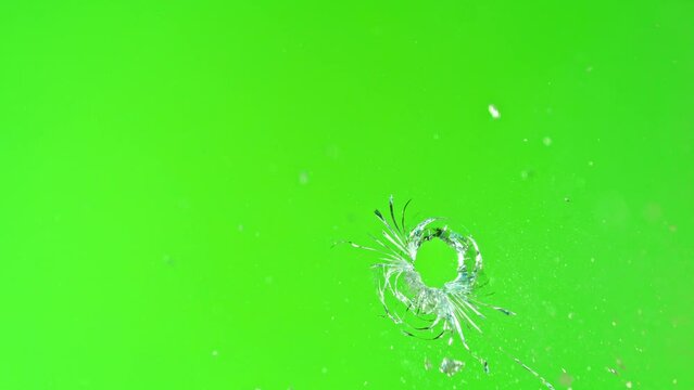 Super slow motion of gunshot through the glass, shattering against green screen background . Filmed on high speed cinema camera, 1000 fps.