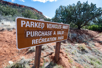 Sign posted on a Sedona hiking trail - parked vehicles must purchase a valid pass