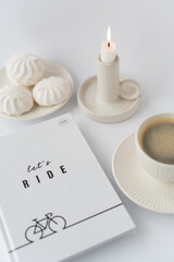 A notebook of notes on a table with a candle and a mug of coffee