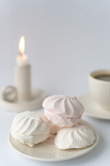Relaxation time. White delicate marshmallows and coffee on white background

