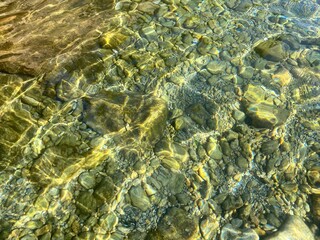 Sea underwater pebbles stones on seabed.