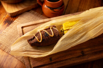 Chocolate Tamale. hispanic dish typical of Mexico and some Latin American countries. Corn dough wrapped in corn leaves. The tamales are steamed. Usually accompanied with atole, hot chocolate or coffee - 762675549