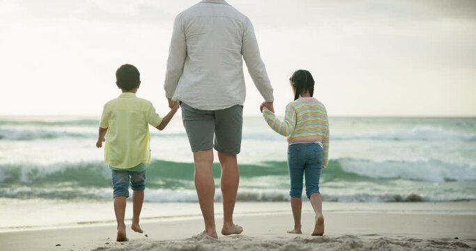 Father, children and holding hands at beach with back, care and connection on vacation in summer. Dad, kids and bonding with love in nature for walk by ocean, waves and sand on holiday with sunshine