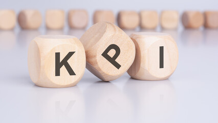 the text 'KPI' - Key Performance Indicators - on wooden cubes, placed on an office desk, suggests a focus on financial analysis, strategic decision-making, and investment evaluation.
