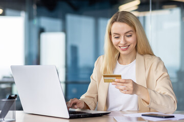 Fototapeta premium Businesswoman with credit card shopping online at office