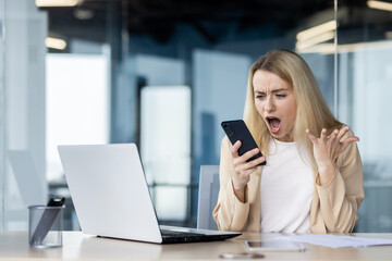 Frustrated businesswoman reacting to smartphone in office