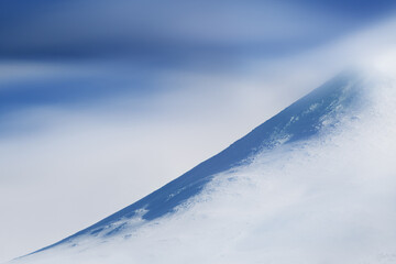 冬山の斜面と流れる雲