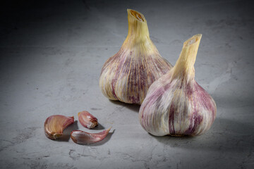 Still life photo of organic whole garlic on a light stone background 4