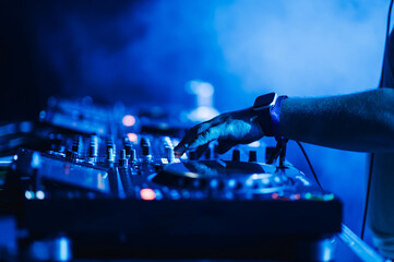 Close up of a dj hand on a mixing console on a performance in a club.