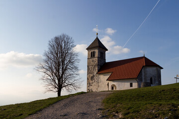 Fototapeta premium A church of saint Ana on top of the hill and tree near it. A church with a tree and the blue skies.