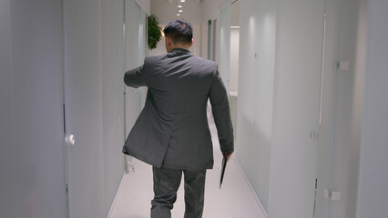 Back view adult businessman Asian ethnic man guy employer going to meeting at office hallway...