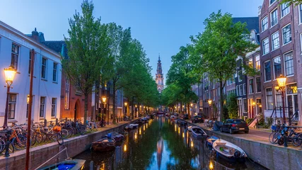 Fototapeten Historic Dutch homes and boats along canal in front of De Oude Kerk © SNEHIT PHOTO