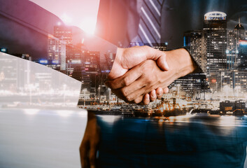 Double exposure image of business people handshake on city office building in background show partnership success of business deal. Concept of corporate teamwork, trust partner and work agreement. uds