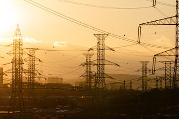 Electrical substation on the sunset background. Power substation and power lines on the background of the sunset. Silhouette. Bright colors. Concept. Horizontal orientation.