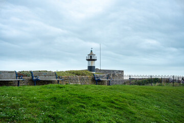 Fototapeta na wymiar lighthouse near the seafront wall