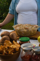 Fresh vegetables and raw meat with spices and oil on the table in nature in the warm sunny light. ingredients ready for cooking on grill outdoors on family picnic 