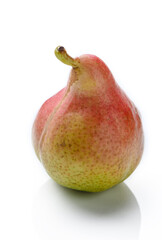 An upright ripe juicy golden and red pear isolated against a flat background.