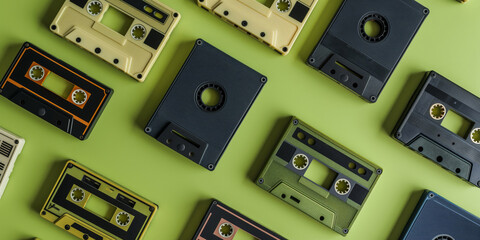 Assortment of retro cassette tapes arranged on a vibrant green backdrop