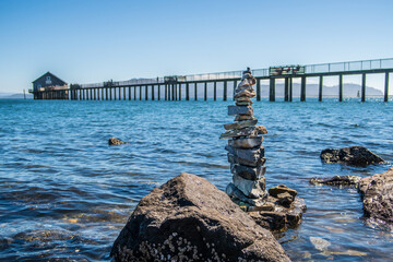 pier in the sea and stacked stones