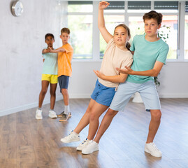 Joyful girl and boy practicing dance in pairs in wellness center