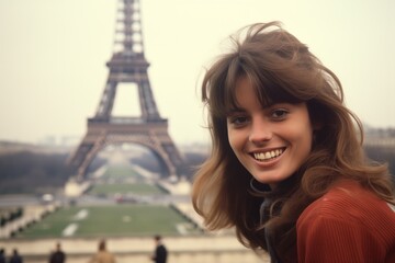 Young caucasian woman smiling at Eiffel Tower in Paris in 1970s