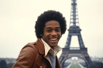  Black man smiling at Eiffel Tower in Paris in 1970s © blvdone