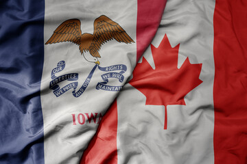 big waving realistic national colorful flag of iowa state and national flag of canada .