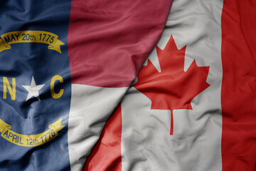 big waving realistic national colorful flag of north carolina state and national flag of canada .