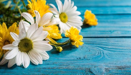floral arrangement of white daisies and yellow flowers scattered on a vibrant blue wooden background