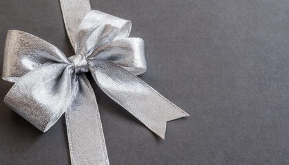 shiny silver gift ribbon bow on gray background