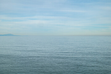 View of the sea on a cloudy day, serene and calm environment, pastel colors.