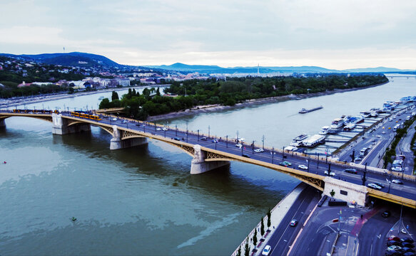 Island Margit and Margit bridge in blue hour twilight in Budapest .Barge moving in water. Yellow trams on stop[ for walkin at island