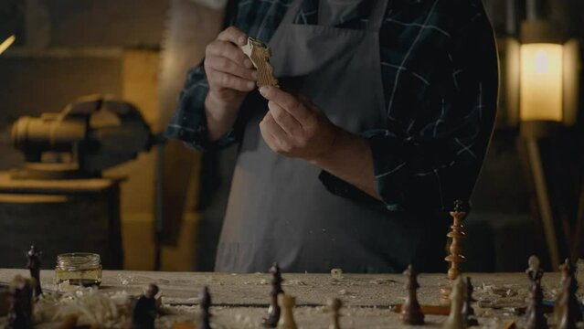 Custom-made chess pieces begin in woodworking workshop. The hands of the master skillfully process every detail, creating work of art from a simple piece of wood. The process of creating chess pieces