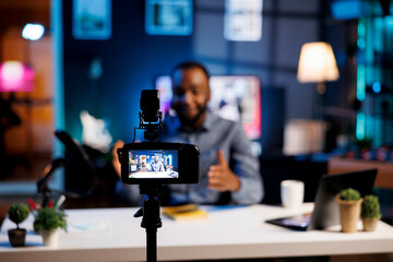 Professional camera used to record tech tutorial on how to repair damaged electronics. Technology guru in blurry background using video production gear to produce content for audience - obrazy, fototapety, plakaty