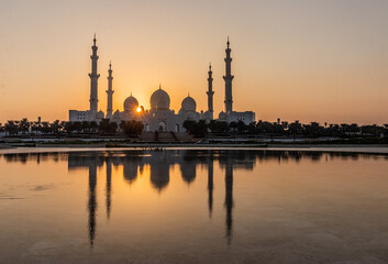 Sunset behind Sheikh Zayed Grand Mosque in Abu Dhabi, United Arab Emirates.