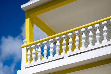 Vivid image of a yellow and white building contrast with a bright blue sky showcasing architectural symmetry