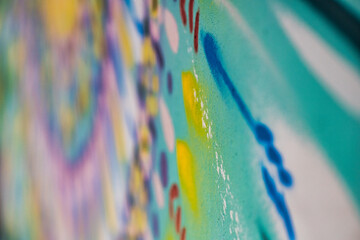 A detailed photograph capturing the vivid colors and textures of spray-painted graffiti on a wall