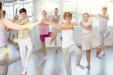 Fototapeta premium Group of boys and girls rehearsing dancehall dance in studio
