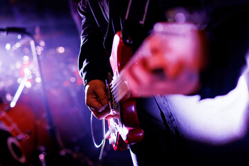Close-up of guitarist hands playing the guitar at the live music festival.