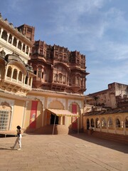 Visite du Fort de Mehrangarh à Jodpur, belle édififice historique de l'ancienne civilisaiton indienne et hindu, magnifique façade de batiment tout coloré, rouge et orange, splendeur touristique  - obrazy, fototapety, plakaty