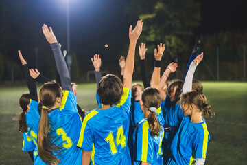 teenage footbal player girls heating up before match and holding hands in the air, team sport concept. High quality photo © PoppyPix