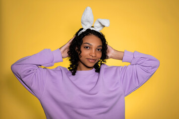happy easter african american girl in bunny ears and sweatshirt on pastel background