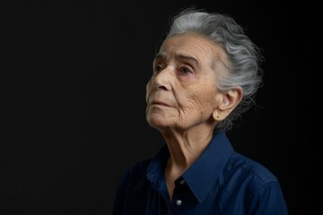 A woman with gray hair and a blue shirt is looking up at the camera